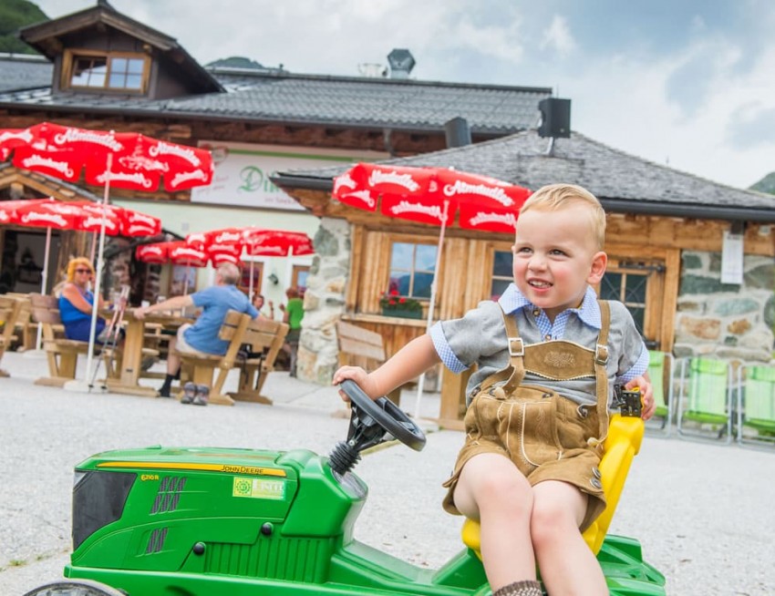Kind spielt mit Traktor am Dikt'n Alm Spielplatz